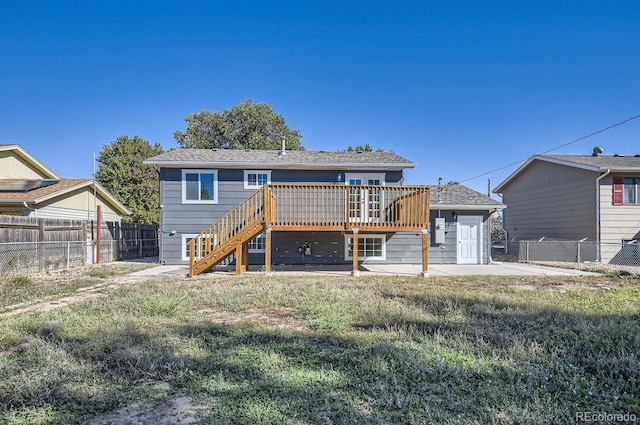 rear view of house featuring a patio area, a lawn, and a deck