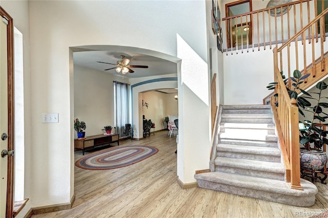1313 Iris Cir, Broomfield, CO 80020 - entryway featuring arched walkways, a ceiling fan, wood finished floors, and stairway