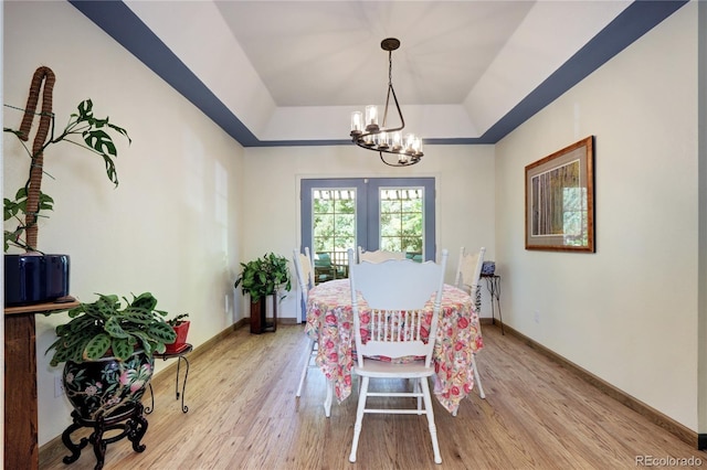 1313 Iris Cir, Broomfield, CO 80020 - dining area featuring a raised ceiling, light wood finished floors, a chandelier, and french doors