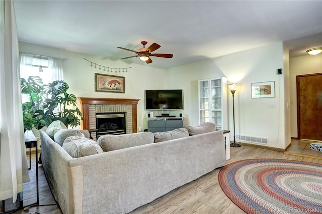 1313 Iris Cir, Broomfield, CO 80020 - living room with a ceiling fan, a brick fireplace, and light wood-type flooring