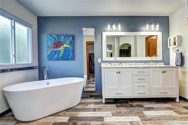 1313 Iris Cir, Broomfield, CO 80020 - full bath featuring double vanity, a freestanding tub, and wood finished floors