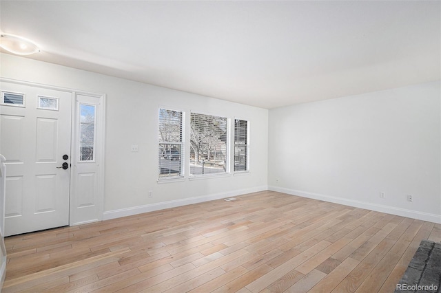 foyer entrance featuring light wood-style flooring and baseboards