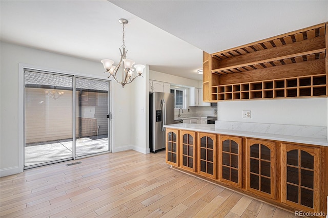 kitchen with visible vents, light wood-style flooring, stainless steel appliances, light countertops, and a sink