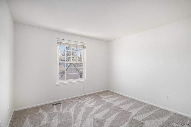 unfurnished room with carpet floors, visible vents, and baseboards