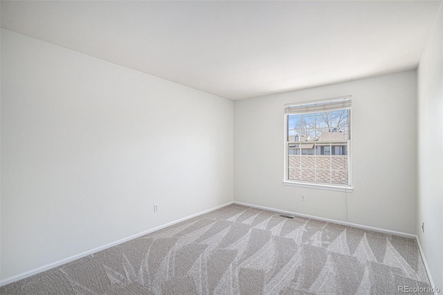 unfurnished room with carpet, visible vents, and baseboards