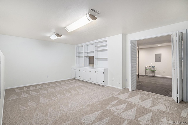 empty room with light carpet, baseboards, visible vents, and electric panel