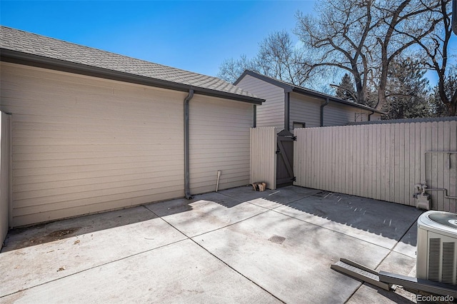 view of patio featuring a gate, fence, and central AC