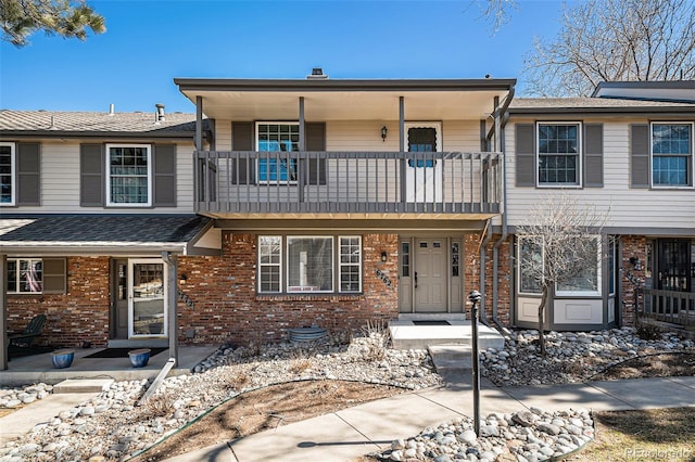 multi unit property with brick siding and a balcony