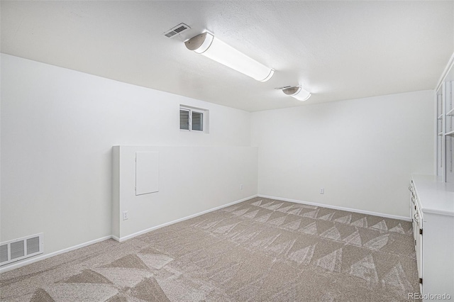 empty room featuring light colored carpet, visible vents, and baseboards