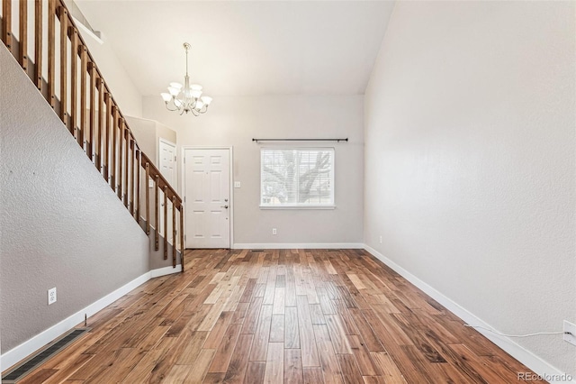 foyer with a chandelier, stairway, baseboards, and wood finished floors