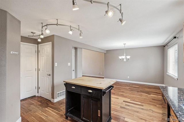 kitchen featuring light wood-style floors, baseboards, and visible vents