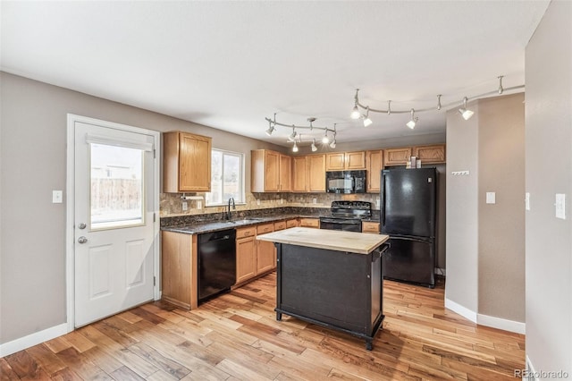 kitchen featuring light wood-style flooring, baseboards, backsplash, and black appliances