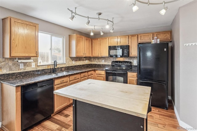 kitchen featuring tasteful backsplash, a sink, light wood-style flooring, and black appliances