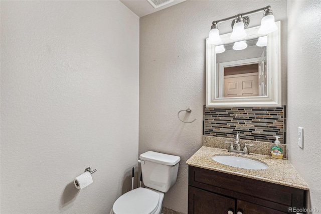 half bath featuring toilet, backsplash, and vanity