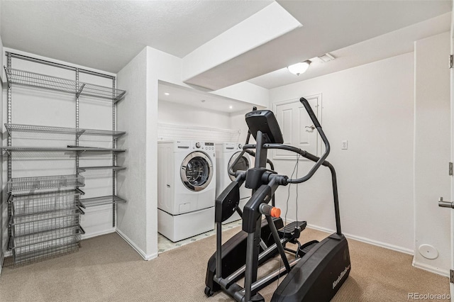 workout area featuring washer and clothes dryer, carpet flooring, and baseboards