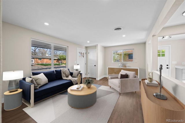 living room featuring recessed lighting, baseboards, visible vents, and wood finished floors