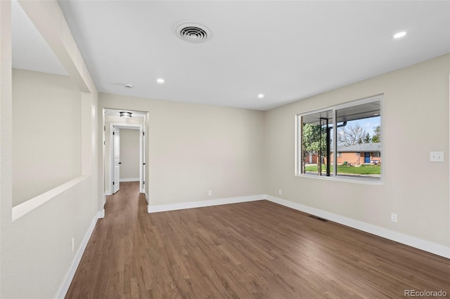 spare room with visible vents, wood finished floors, and baseboards