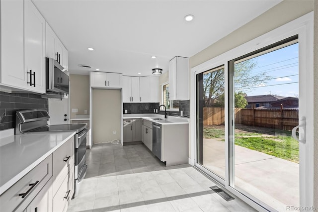 kitchen with stainless steel appliances, visible vents, light countertops, decorative backsplash, and recessed lighting