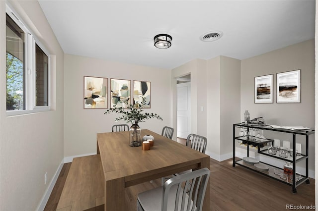 dining room featuring baseboards, dark wood-style floors, and visible vents