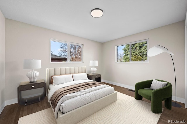 bedroom featuring baseboards, visible vents, and wood finished floors
