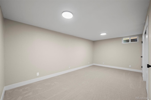 below grade area featuring light carpet and baseboards