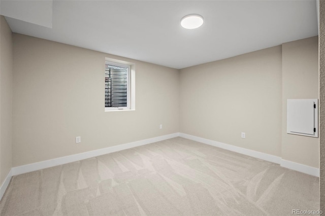 unfurnished room with baseboards and light colored carpet
