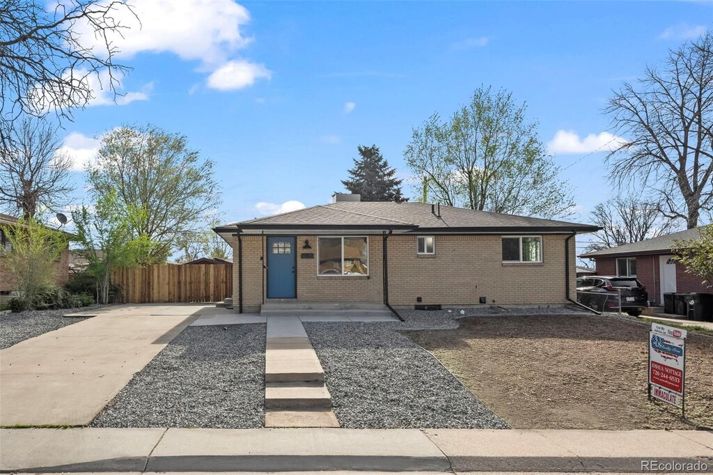 7496 Clay St, Westminster, CO 80030 - view of front of property with fence, brick siding, and concrete driveway