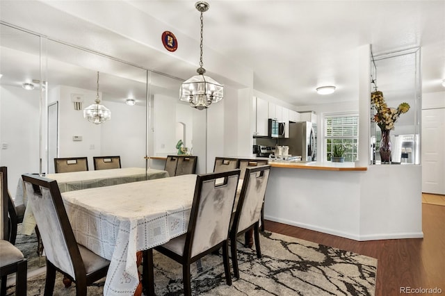 1885 S Quebec Way Unit G104, Denver, CO 80231 - dining space featuring a chandelier, wood finished floors, and baseboards
