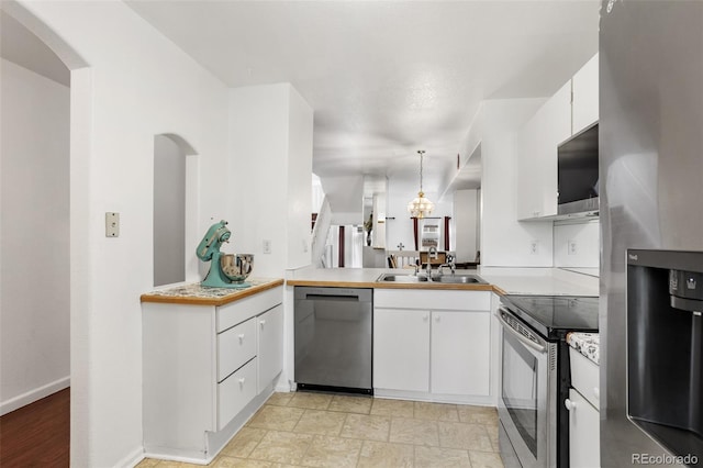 1885 S Quebec Way Unit G104, Denver, CO 80231 - kitchen featuring stainless steel appliances, a sink, white cabinetry, light countertops, and hanging light fixtures