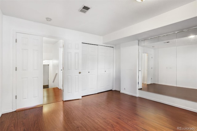 1885 S Quebec Way Unit G104, Denver, CO 80231 - unfurnished bedroom featuring wood finished floors, baseboards, and a closet