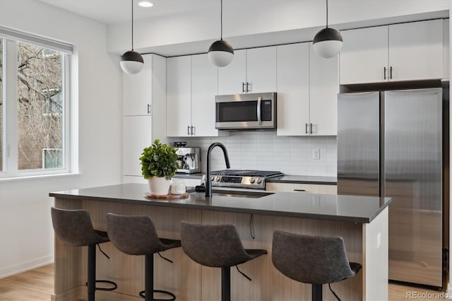 3101 W 47th Ave Unit 14, Denver, CO 80211 - kitchen with stainless steel appliances, a sink, dark countertops, tasteful backsplash, and recessed lighting