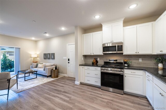 9992 W Victoria Pl Unit 103, Littleton, CO 80127 - kitchen with appliances with stainless steel finishes, decorative backsplash, light wood-style floors, white cabinetry, and recessed lighting