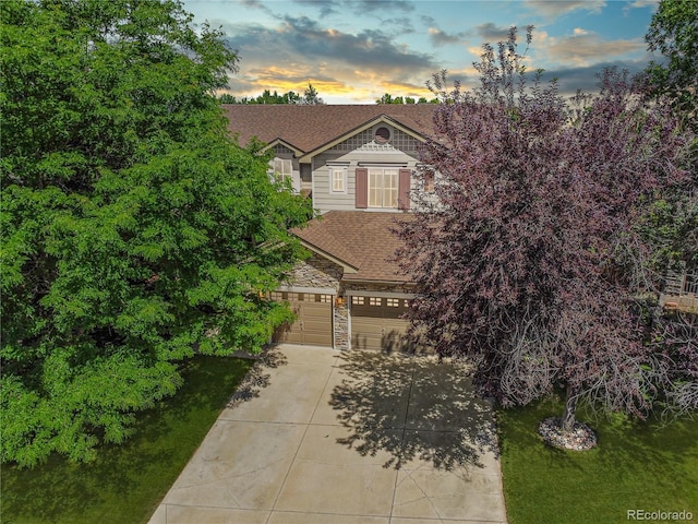 9644 S Estes Way, Littleton, CO 80127 - view of front facade with an attached garage, driveway, stone siding, and roof with shingles