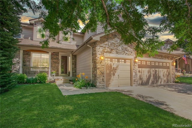 9644 S Estes Way, Littleton, CO 80127 - view of front facade with stone siding, a front lawn, driveway, an attached garage, and covered porch