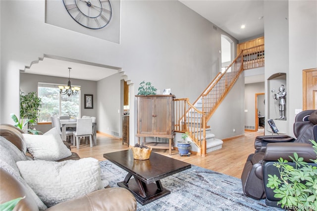 9644 S Estes Way, Littleton, CO 80127 - living area with a towering ceiling, arched walkways, a chandelier, light wood-type flooring, and stairs