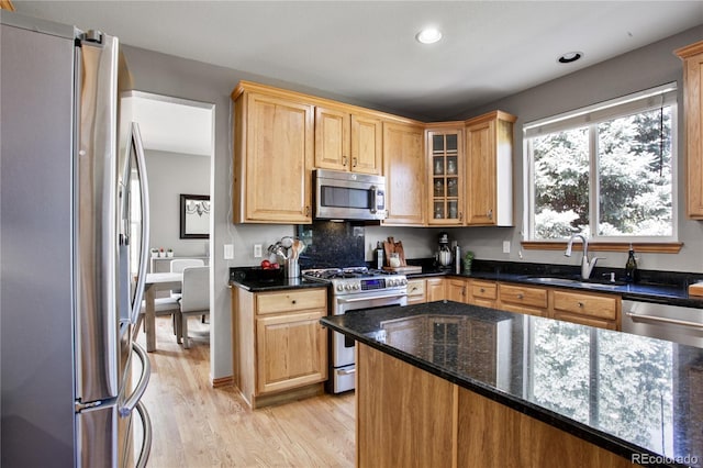 9644 S Estes Way, Littleton, CO 80127 - kitchen with appliances with stainless steel finishes, light wood-style floors, dark stone countertops, glass insert cabinets, and recessed lighting