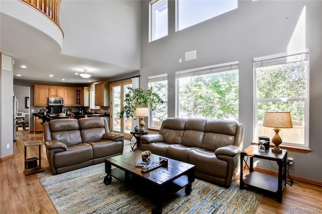 9644 S Estes Way, Littleton, CO 80127 - living room featuring healthy amount of natural light, a high ceiling, light wood-type flooring, and recessed lighting