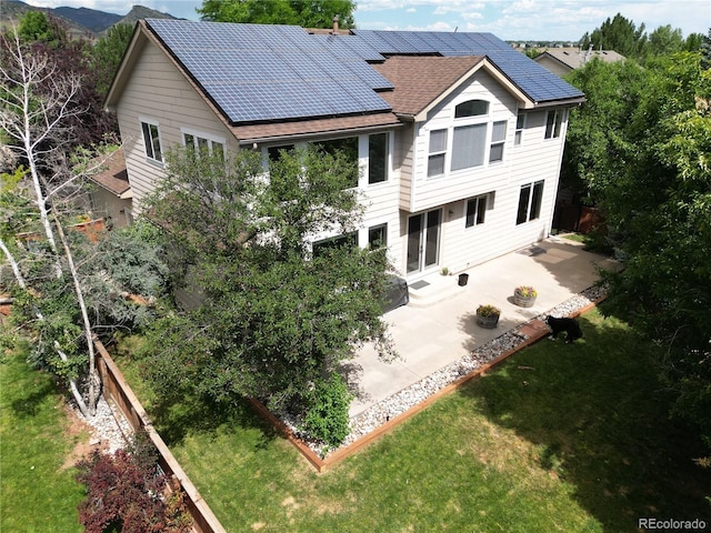 9644 S Estes Way, Littleton, CO 80127 - rear view of property featuring a patio, solar panels, a yard, and a shingled roof