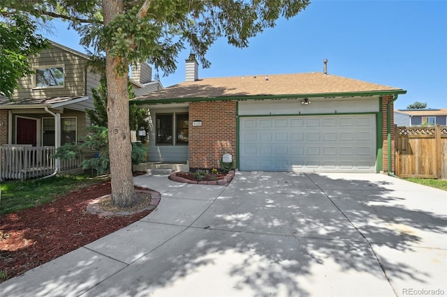 9125 Lowell Ct, Westminster, CO 80031 - view of front of home with driveway, brick siding, an attached garage, and a chimney