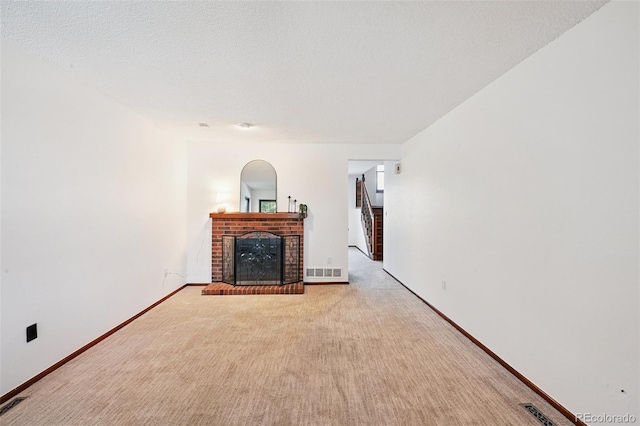 9125 Lowell Ct, Westminster, CO 80031 - unfurnished living room with a brick fireplace, carpet flooring, a textured ceiling, and arched walkways