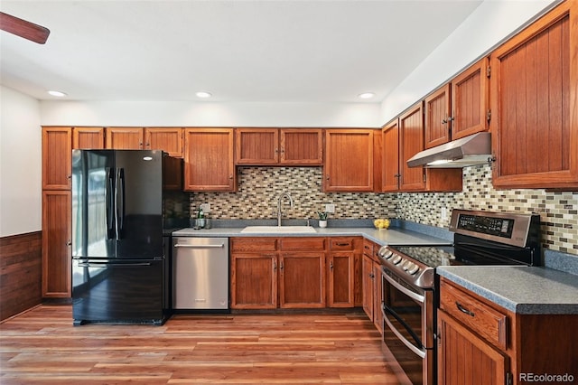 9125 Lowell Ct, Westminster, CO 80031 - kitchen featuring appliances with stainless steel finishes, under cabinet range hood, light wood finished floors, brown cabinetry, and recessed lighting