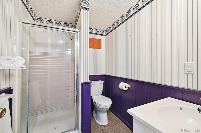 9125 Lowell Ct, Westminster, CO 80031 - full bathroom featuring a wainscoted wall, a stall shower, vanity, and a textured ceiling