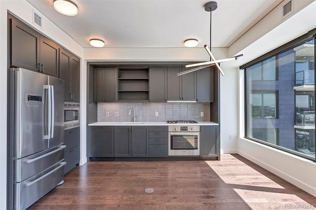 1750 Wewatta St Unit 1102, Denver, CO 80202 - kitchen with appliances with stainless steel finishes, open shelves, light countertops, tasteful backsplash, and dark wood finished floors