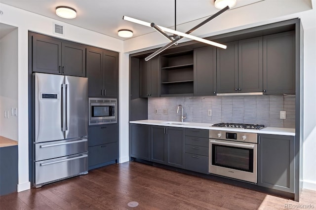1750 Wewatta St Unit 1102, Denver, CO 80202 - kitchen with appliances with stainless steel finishes, light countertops, dark wood finished floors, open shelves, and decorative backsplash