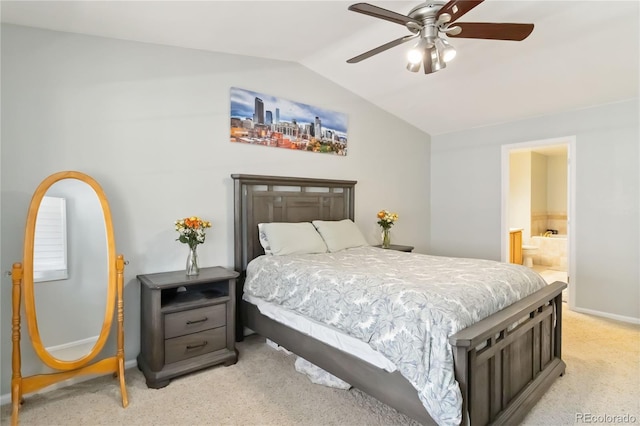 bedroom featuring lofted ceiling, baseboards, ensuite bathroom, light colored carpet, and a ceiling fan