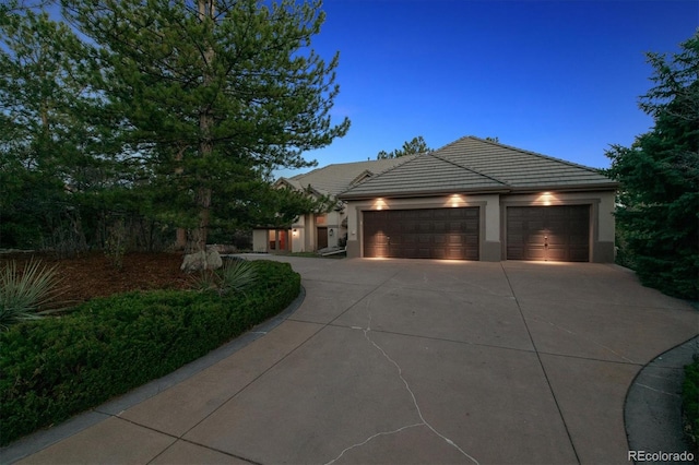 902 Anaconda Ct, Castle Rock, CO 80108 - view of front of house featuring an attached garage, a tiled roof, stucco siding, and driveway