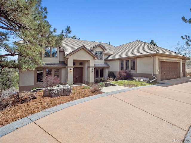 902 Anaconda Ct, Castle Rock, CO 80108 - traditional home featuring an attached garage, concrete driveway, stucco siding, and a tile roof