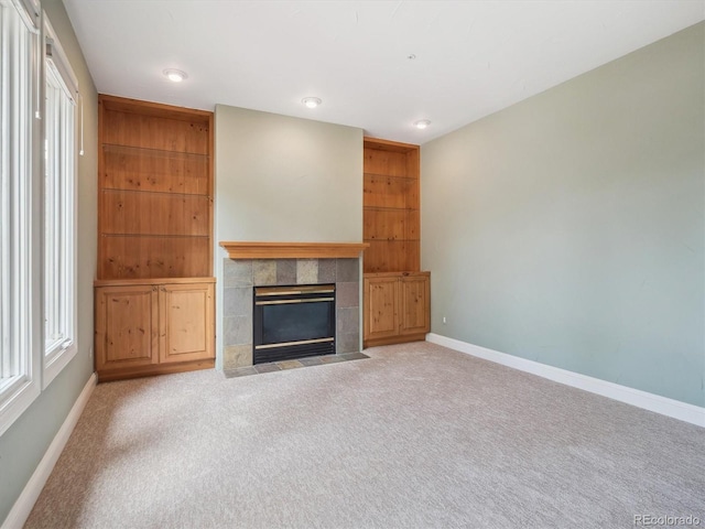 902 Anaconda Ct, Castle Rock, CO 80108 - unfurnished living room featuring carpet floors, baseboards, a healthy amount of sunlight, and a tile fireplace