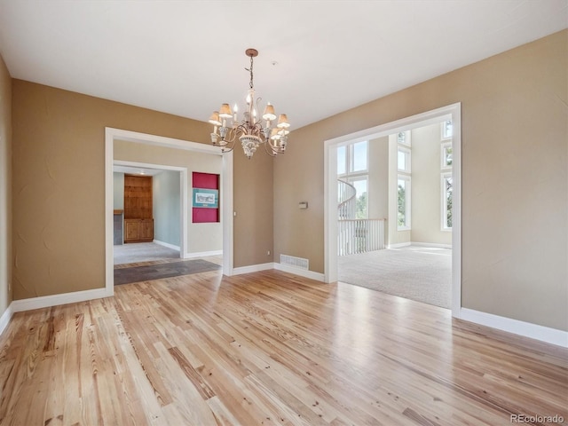 902 Anaconda Ct, Castle Rock, CO 80108 - unfurnished dining area with baseboards, a notable chandelier, light wood-style flooring, and visible vents