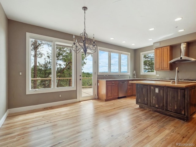 902 Anaconda Ct, Castle Rock, CO 80108 - kitchen with light wood finished floors, wall chimney range hood, a notable chandelier, and baseboards